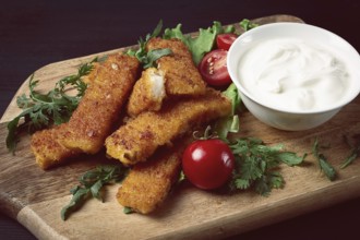 Fried fish nuggets, with white sauce, arugula and cherry, no people