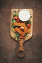 Fried fish nuggets, with white sauce, arugula and cherry, no people