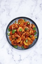 Grilled shrimp, unpeeled, headless, with spices, on a marble table, homemade, no people