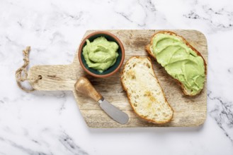 Ciabatta with avocado pasta, breakfast, on a chopping board, top view, homemade, no people