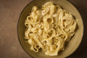 Fettuccine, tagliatelle, in creamy garlic sauce, Italian traditional cuisine, pasta carbonaro