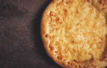 Khachapuri in Megrelian, a traditional Georgian dish, flatbread with cheese, top view, no people