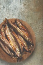 Cold smoked capelin, on a wooden bowl, top view, no people
