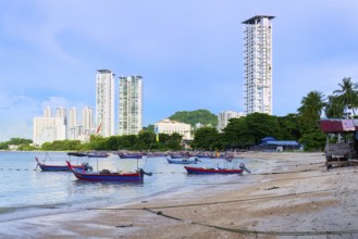 Fishing boats and George Town skyline along the Malacca Strait near Penang Floating Mosque, Penang,