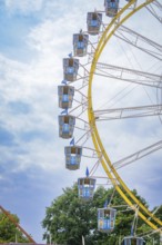 Detailed view of a giant Ferris wheel with blue cabins in front of a blue sky, Olympic Park,