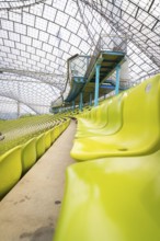 Interior of a stadium with yellow seats and a modern roof structure, Olympiapark, Munich, Germany