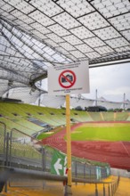 View of stadium grandstand and running track, dominated by a metal grid construction and
