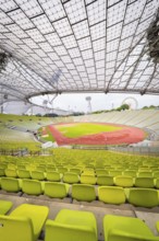 Panoramic view of stadium with yellow-green seats and red running track under a filigree roof,