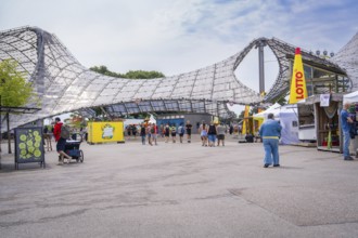 People enjoying a leisure event in a modern architectural setting, Olympiapark, Munich, Germany