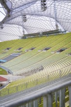 View of empty rows of seats under a striking glass roof of a sports facility, Olympiapark, Munich,