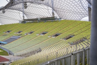 Detail view of green rows of seats in an empty modern stadium with glass roof, Olympiapark, Munich,