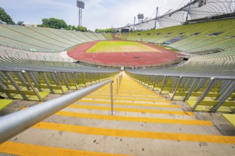 Central view of the stadium from the stairs onto empty stands and red running track, Olympic Park,