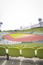 View of an empty stadium with green seats and red running track, Olympiapark, Munich, Germany