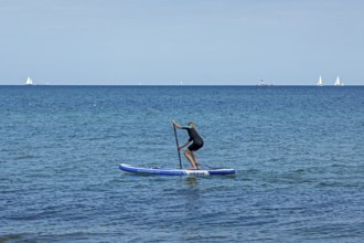 Girl stand-up paddling, Strande, Schleswig-Holstein, Germany