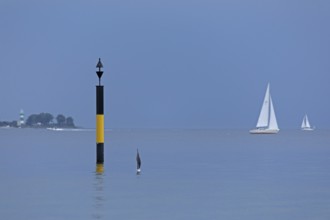 Black-yellow navigation mark, in the background lighthouse Bülk, sailing boats, Falckenstein, Kiel,