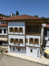 A single historic building with wooden windows and a red roof on a sunny day, aerial view,