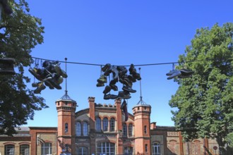 Shoes hanging on a leash, in the courtyard of a residential home for addicts, each shoe is a