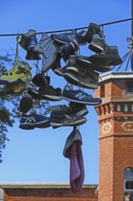 Shoes hanging on a leash in the courtyard of a residential home for addicts, each shoe a reminder