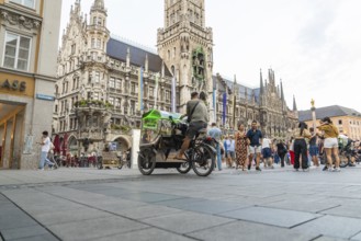 Lively town hall square with tourists in front of impressive Gothic architecture, Marienplatz,
