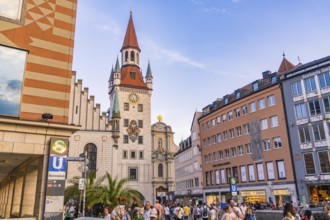 Busy street in front of historic tower with people in the city centre on a clear day, Munich,