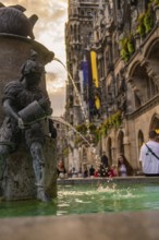 Fountain with sculpture and flowing water in front of the New Town Hall, Munich, Germany