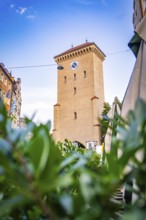 Historic clock tower in an urban setting with blue sky, Munich, Germany