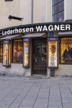 Traditional shop for lederhosen with illuminated shop window, Munich, Germany