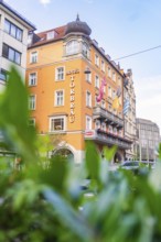 Municipal hotel building with orange-coloured façade, Munich, Germany