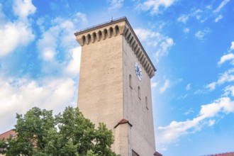 Historic clock tower with clock face in front of a blue sky, Munich, Germany