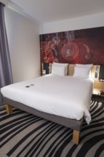 Modern hotel room with comfortable double bed, stylish decoration and elegant furnishings, Munich,