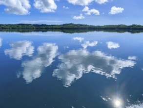 White clouds cumulus reflected in water surface of tropical lagoon of Yap Island in Pacific Ocean,