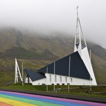 Street painted in the colours of the rainbow and the fish-shaped church designed by Hákon