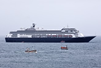 Cruise ship at sea with several small excursion boats for whale watching, Husavik, Iceland