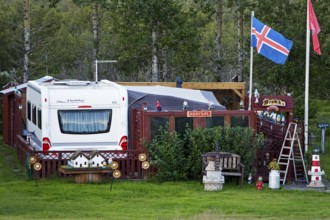 Icelandic permanent camper with full decoration and Icelandic flag at the campsite in Uthlid in