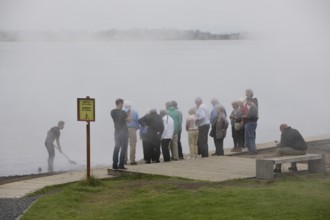 Tourist group at the lake Laugarvatn in the steam of the warm springs, South Iceland, Iceland