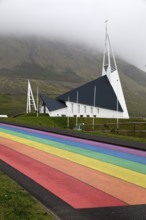 Street painted in the colours of the rainbow and the fish-shaped church designed by Hákon