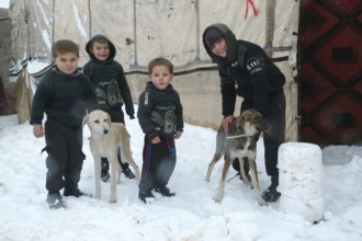 Displaced Syrian families and children living in refugee camps during harsh winter conditions,