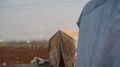 Worn-out tents housing Syrian refugees near the Turkish border, showing the dire humanitarian