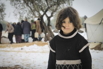 Displaced Syrian families and children living in refugee camps during harsh winter conditions,
