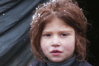 Displaced Syrian families and children living in refugee camps during harsh winter conditions,