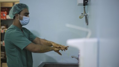 A doctor washing his hands before entering the operating room to perform surgery. Aleppo, Syria