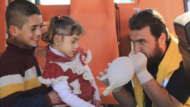 Displaced Syrian children receiving urgent medical intervention inside an ambulance, reflecting the