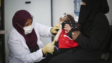 A doctor examines children's malnutrition inside a refugee camp. Malnutrition was measured using a