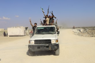 Fighters from the Free Syrian Army celebrate victory after capturing villages that were under the