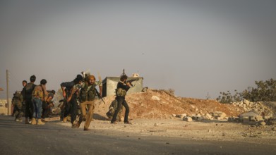 Syrian opposition fighters firing small arms and heavy weapons during the expulsion of ISIS