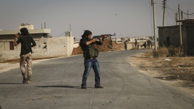 Syrian opposition fighters firing small arms and heavy weapons during the expulsion of ISIS