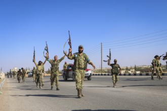 Fighters from the Free Syrian Army celebrate victory after capturing villages that were under the