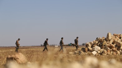 Military fighters carrying a wounded man injured during a battle against ISIS in northern Syria.