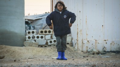 A Syrian refugee child photographed in a camp, reflecting the harsh living conditions of displaced