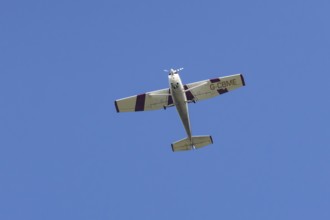 Reims Cessna F172M Skyhawk light aircraft flying in a blue sky, England, United Kingdom